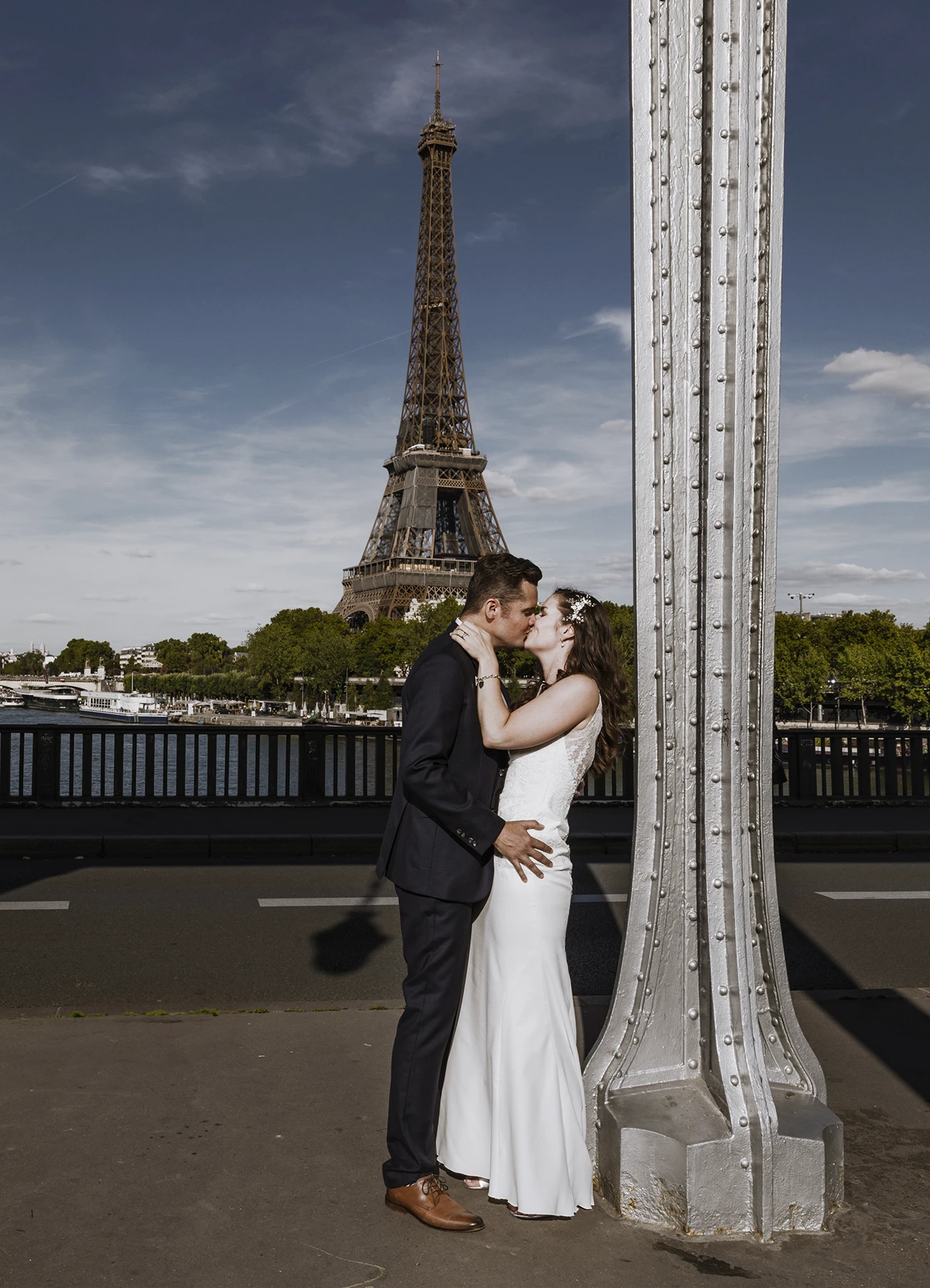Mariés posant sur le pont Bir Hakeim avec la Tour Eiffel en arrière-plan, photographiés par Laurène Zabary.