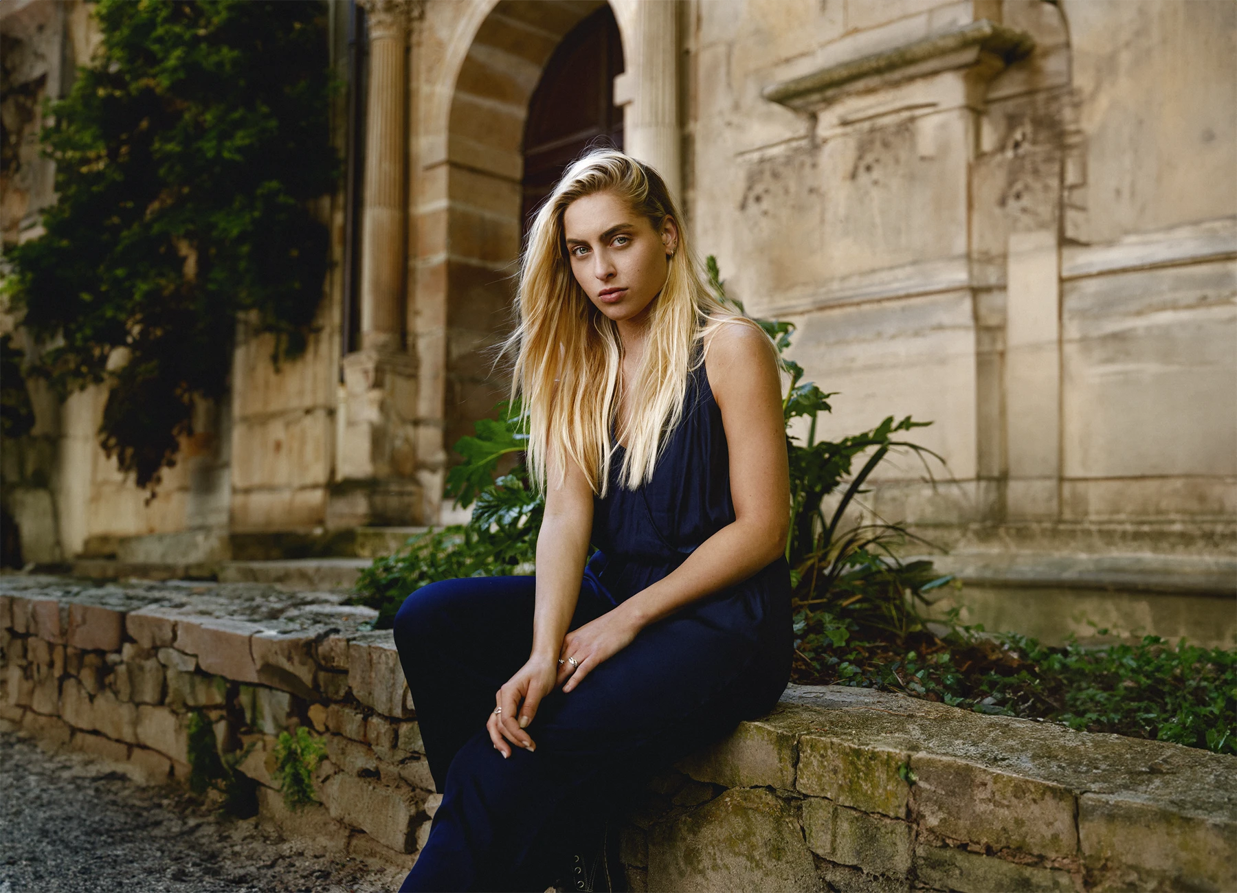 Candice, jeune femme blonde, dans le jardin du Musée Cluny, en combinaison bleue, regardant l'objectif. Photo par Laurène Zabary