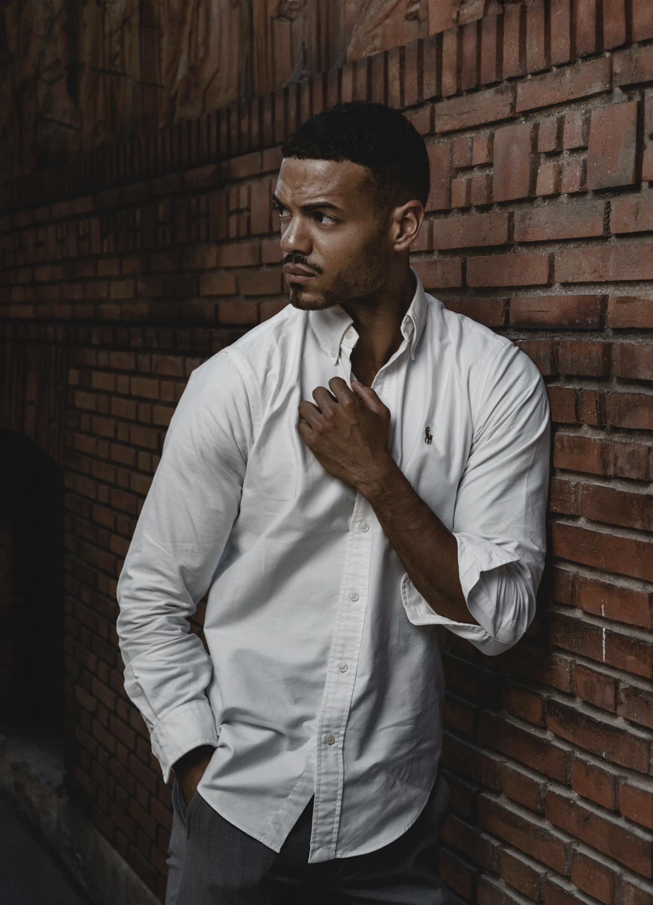 Théo Gontrand, mannequin, posant devant un mur de briques à Paris. Photo par Laurène Zabary