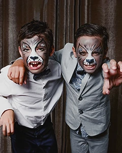 Portrait de deux enfants maquillés en loup, pris devant une draperie lors d'une soirée sur le thème des années 20 à l'hôtel Vernet, par Laurène Zabary.