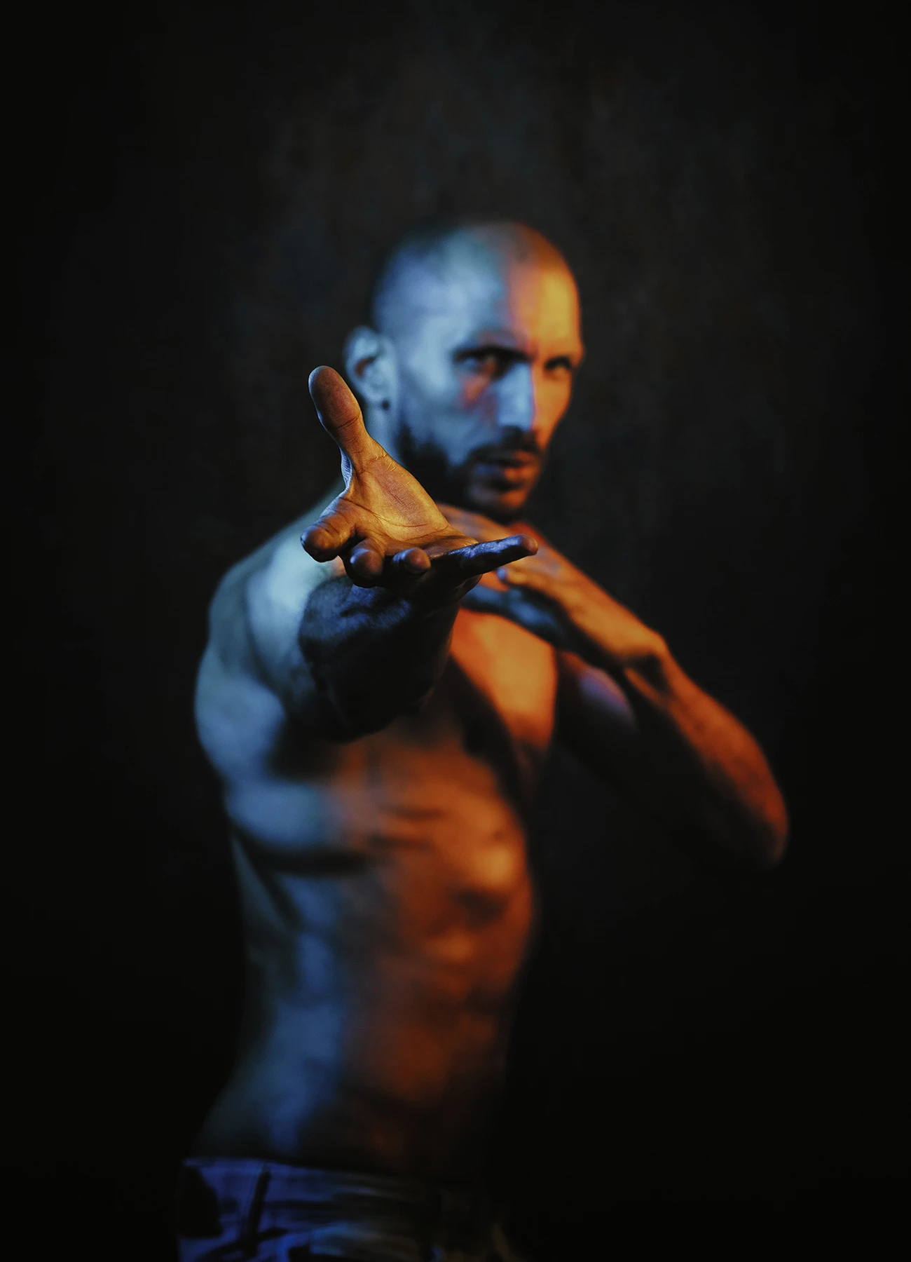 Mike adopte une posture de combat déterminée, éclairé par des lumières jaunes et bleues sur fond noir.