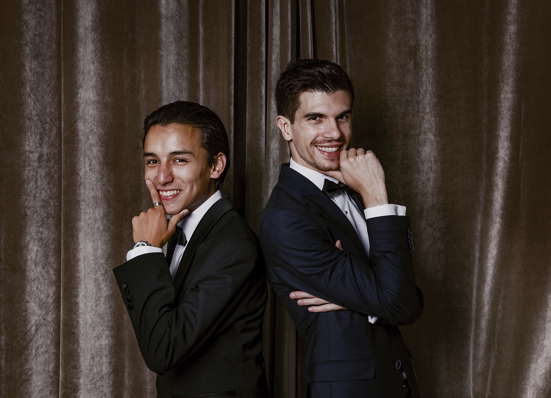 Portrait de deux hommes posant dos à dos, chacun se tenant le menton devant une draperie, réalisé lors d’une soirée d’anniversaire sur le thème des années 20 à l’hôtel Vernet par Laurène Zabary.