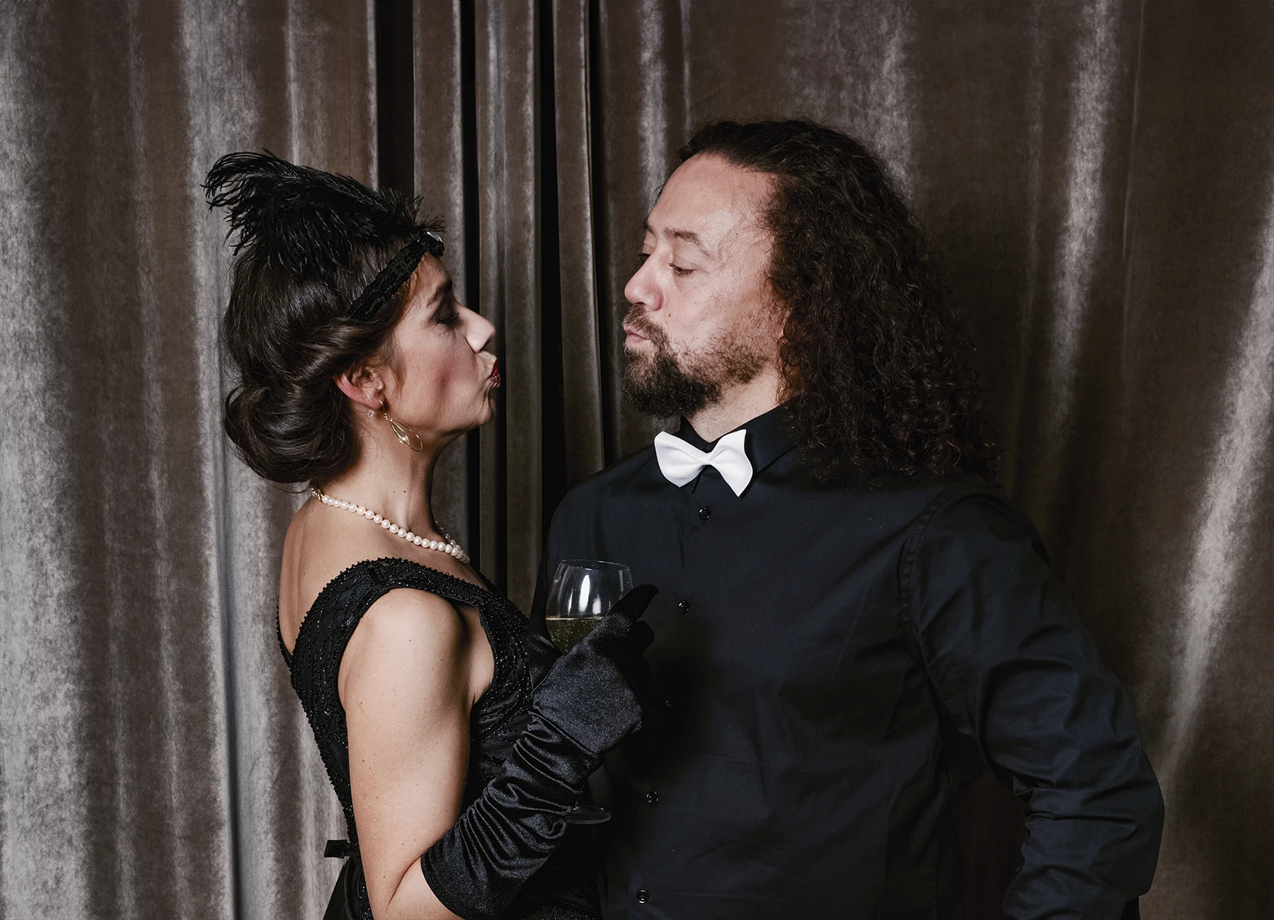 Portrait d’un couple qui s’embrasse devant une draperie, réalisé lors d’une soirée d’anniversaire sur le thème des années 20 à l’hôtel Vernet par Laurène Zabary.