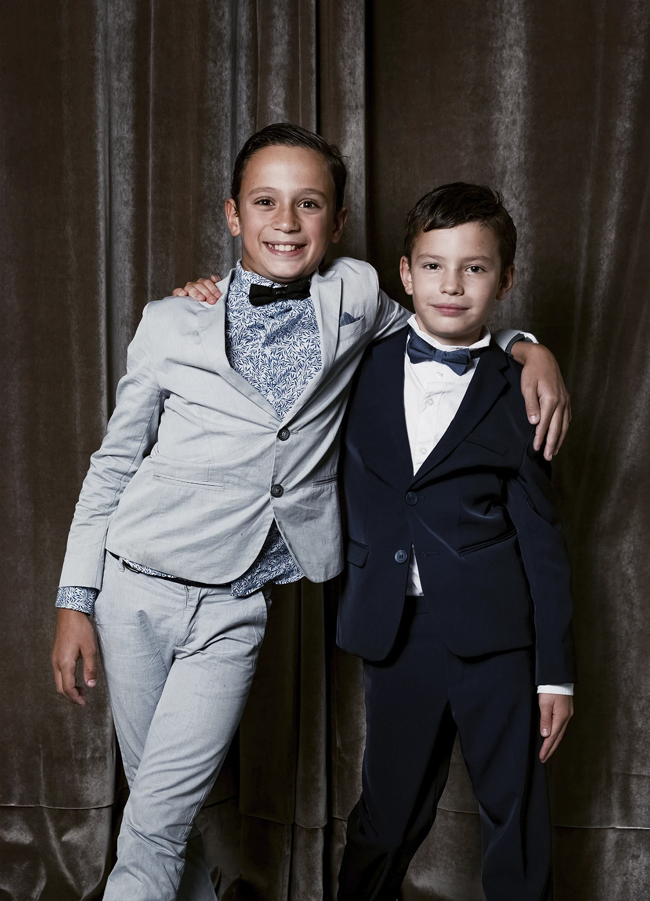 Portrait de deux enfants habillés très élégamment, posant devant une draperie, réalisé lors d’une soirée d’anniversaire sur le thème des années 20 à l’hôtel Vernet par Laurène Zabary.