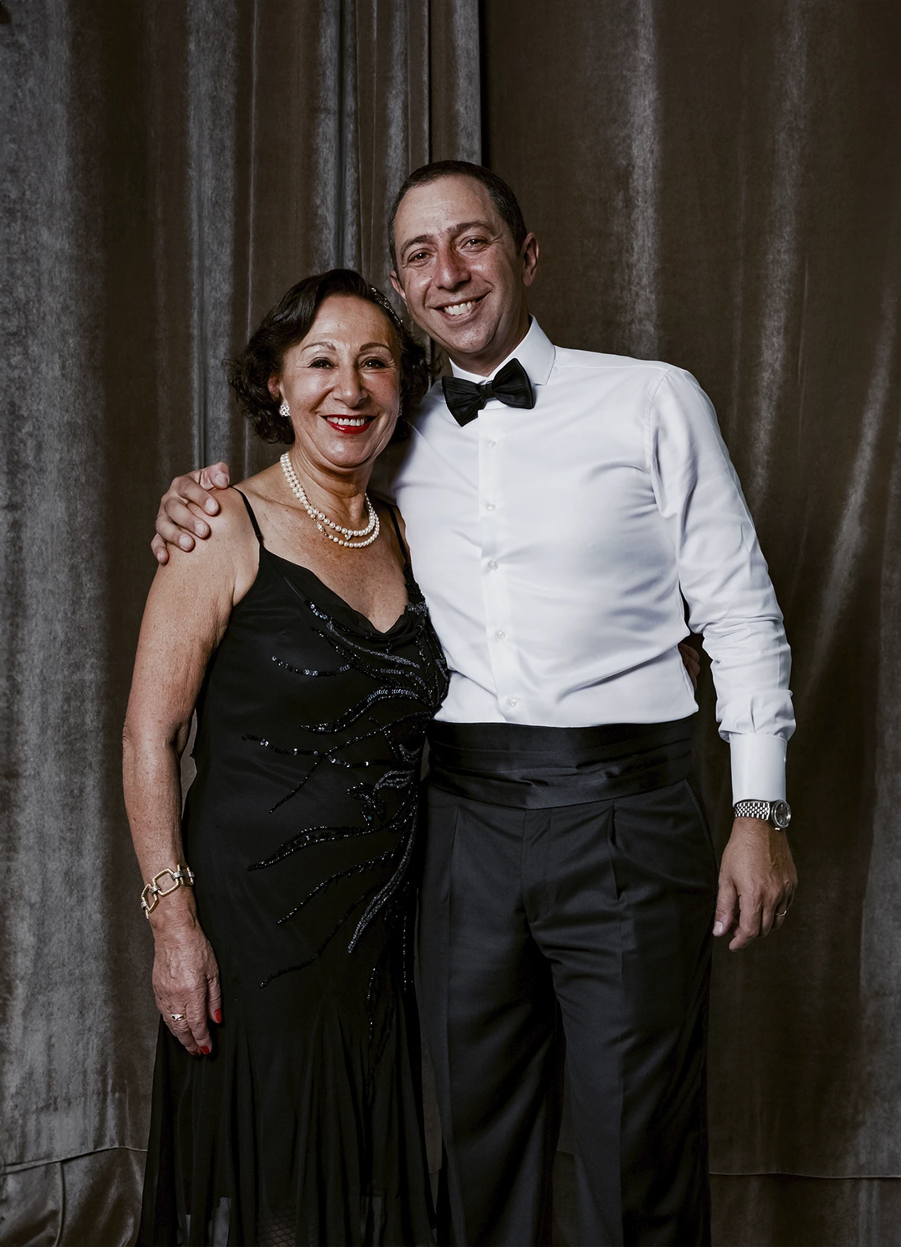 Portrait d’un homme et d’une femme posant devant une draperie, réalisé lors d’une soirée d’anniversaire à l’hôtel Vernet par Laurène Zabary.
