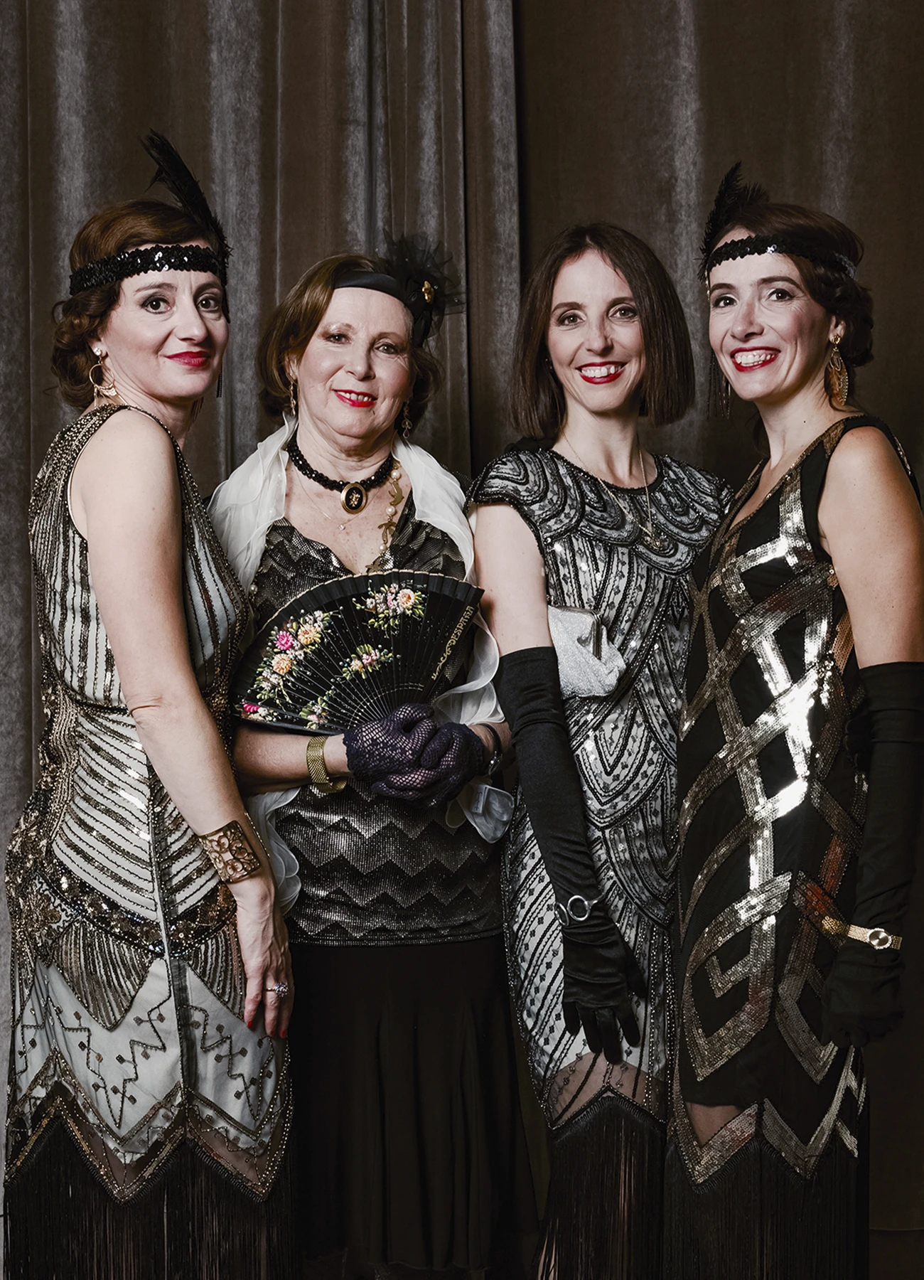 Portrait de quatre femmes en tenue des années 20 posant devant une draperie, réalisé lors d’une soirée d’anniversaire à l’hôtel Vernet par Laurène Zabary.