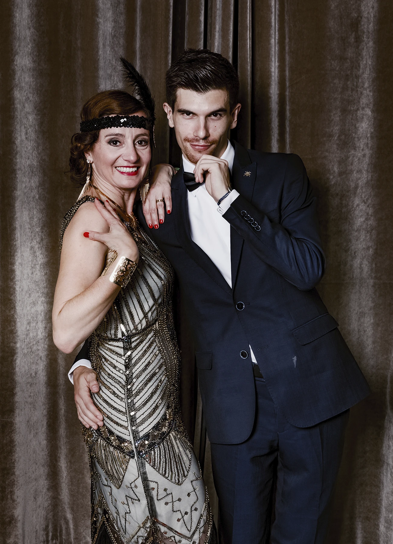 Portrait d’un homme et d’une femme dans une attitude festive, posant devant une draperie, réalisé lors d’une soirée d’anniversaire sur le thème des années 20 à l’hôtel Vernet par Laurène Zabary.