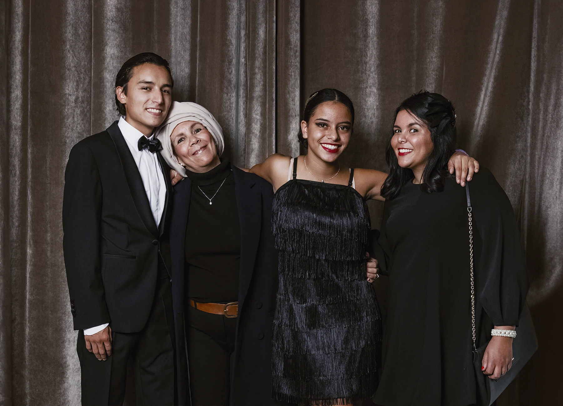 Portrait de quatre personnes posant devant une draperie, réalisé lors d’une soirée d’anniversaire sur le thème des années 20 à l’hôtel Vernet par Laurène Zabary.