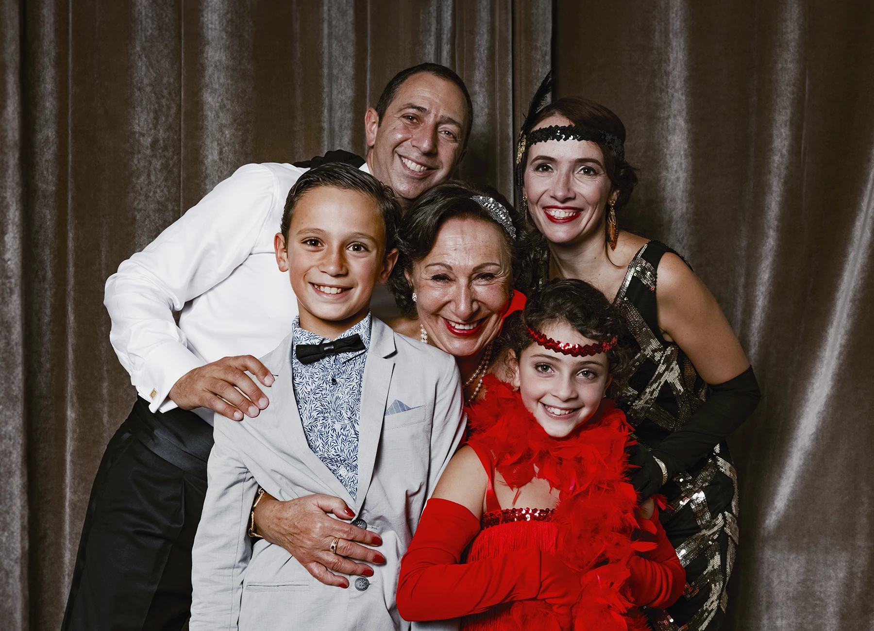 Portrait d’une famille posant devant une draperie, réalisé lors d’une soirée d’anniversaire sur le thème des années 20 à l’hôtel Vernet par Laurène Zabary.