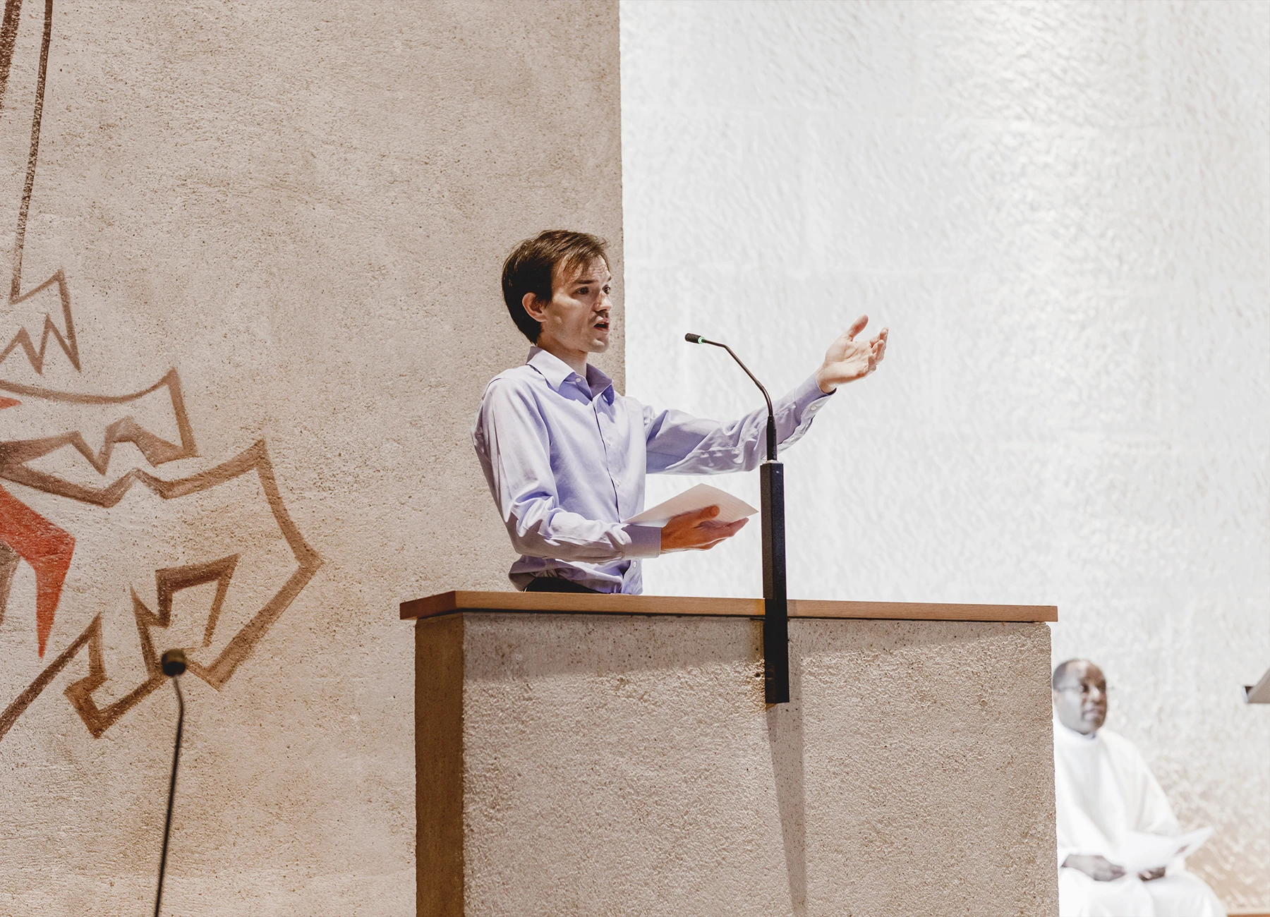 Une personne dirige le chant dans l’église Saint-Joseph de Montrouge durant la cérémonie de baptême, photographiée par Laurène Zabary.