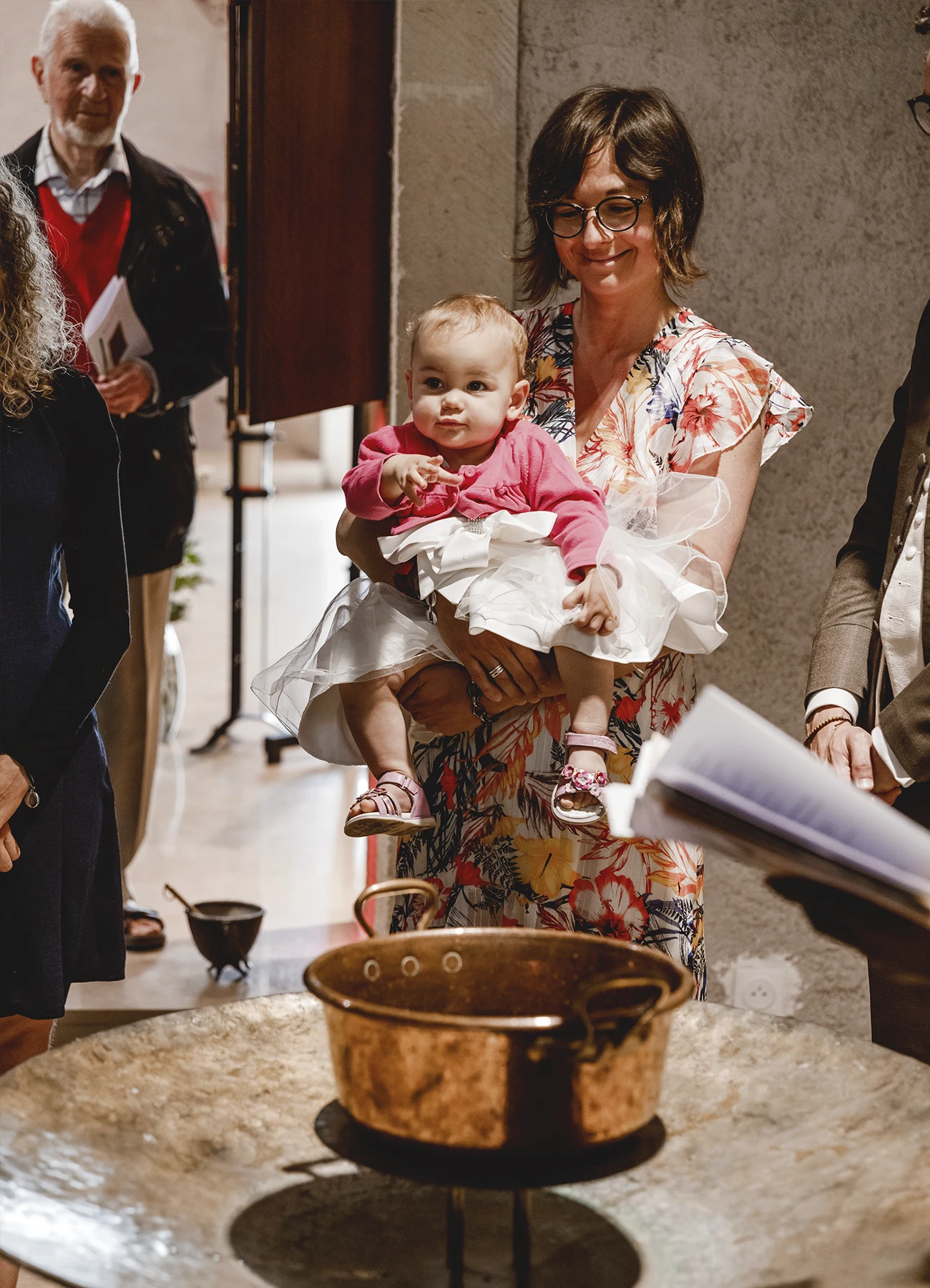 Une mère et son bébé devant les fonts baptismaux à l’église Saint-Joseph de Montrouge, photographiés par Laurène Zabary.