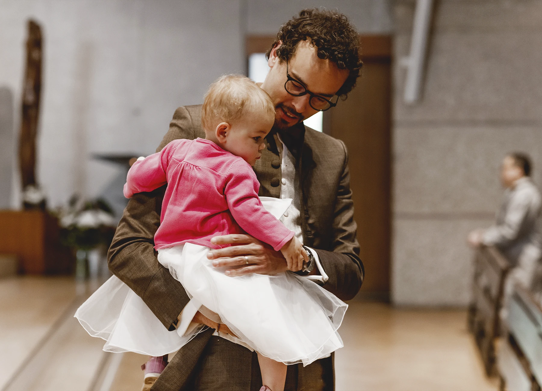 Le bébé dans les bras de son père dans l’église Saint-Joseph de Montrouge durant le baptême, photographié par Laurène Zabary.