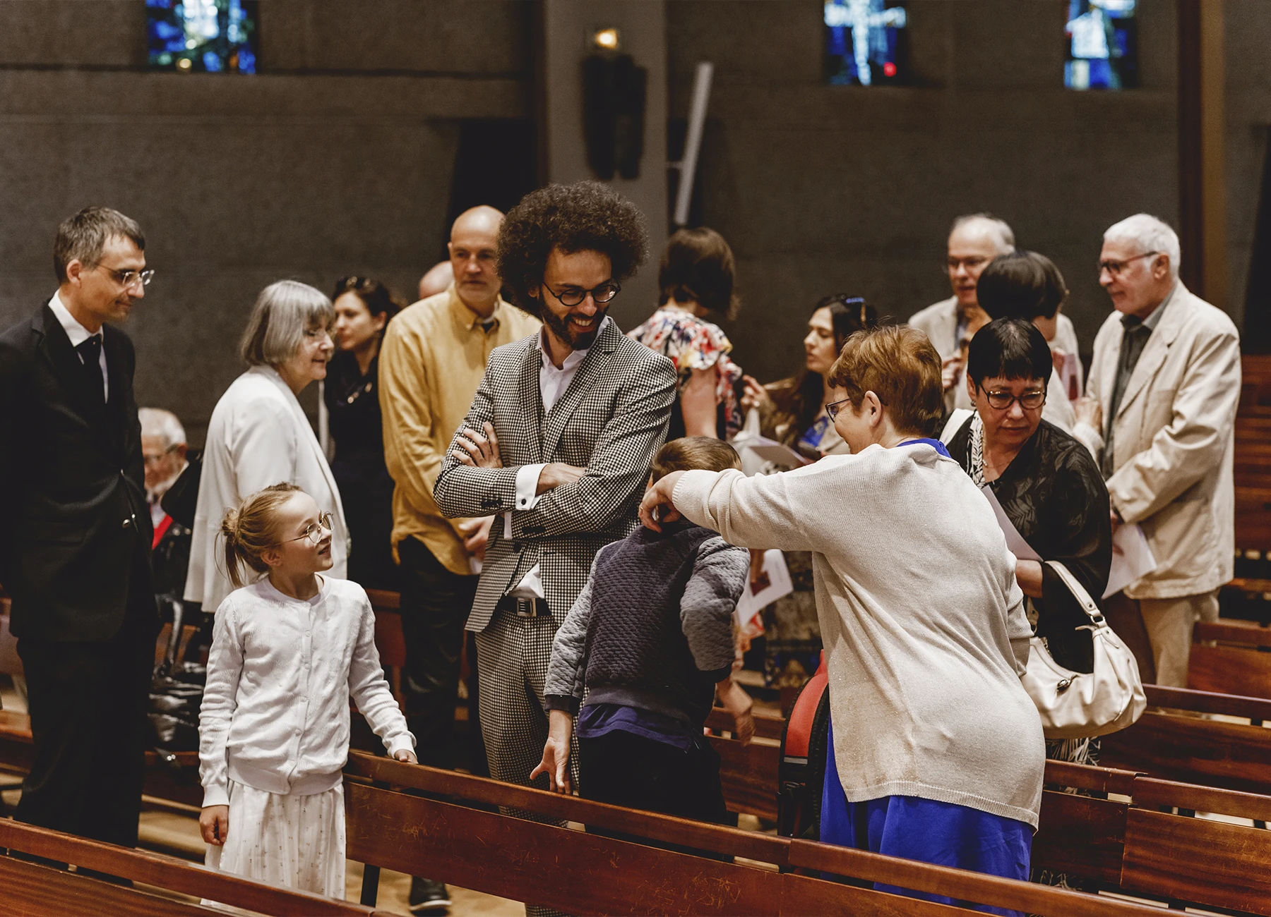 La famille s’installe dans l’église Saint-Joseph de Montrouge avant le début de la cérémonie de baptême, capturée par Laurène Zabary.