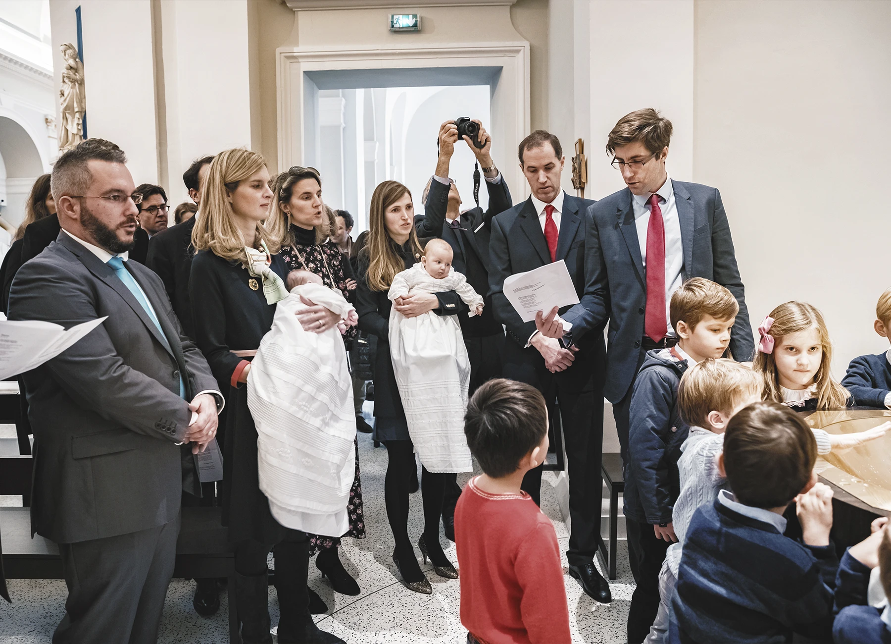 La famille et les invités se rassemblent près du bassin pour le baptême.