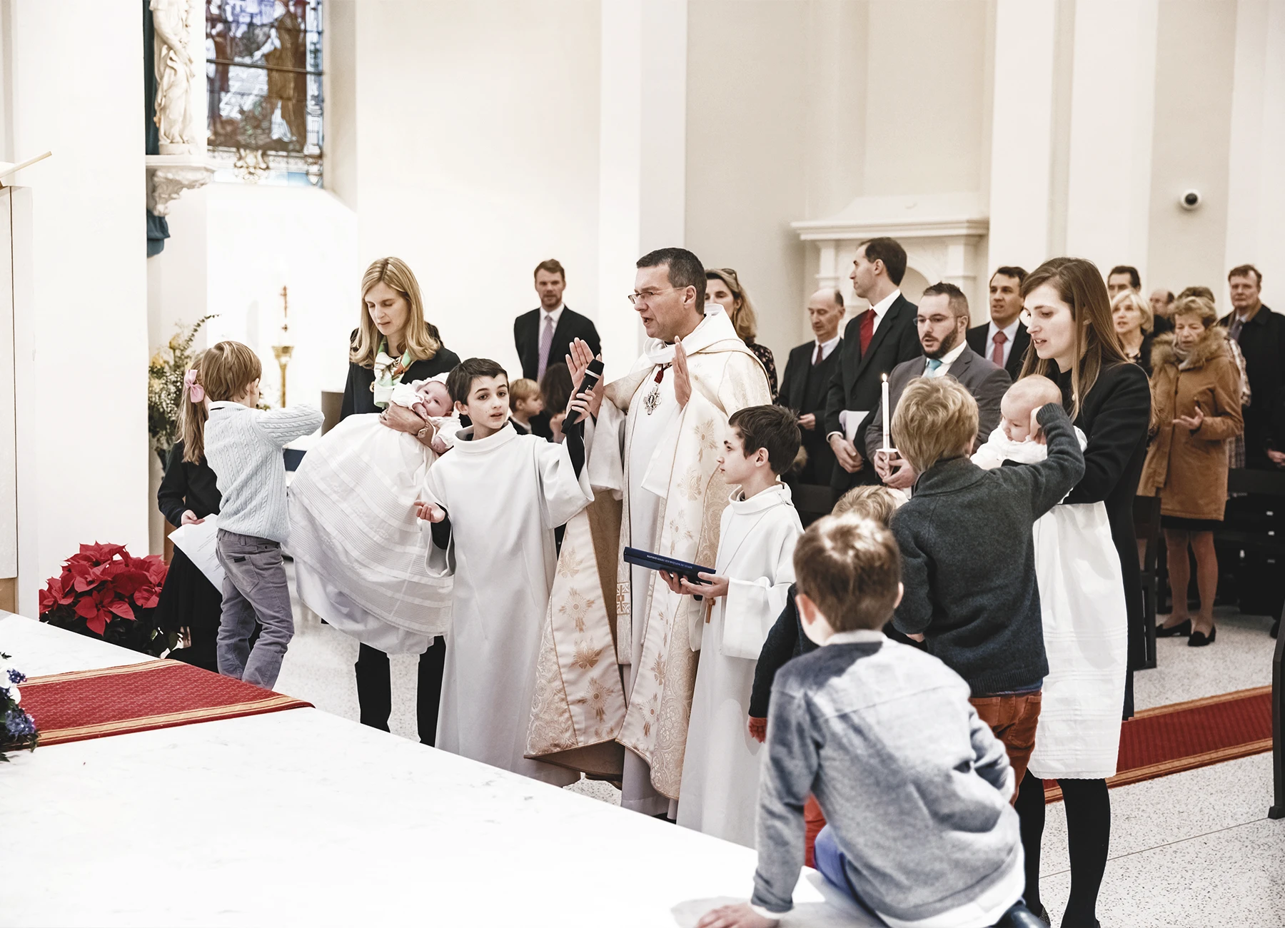 Le prêtre, les enfants de chœur et les parents réunis en prière