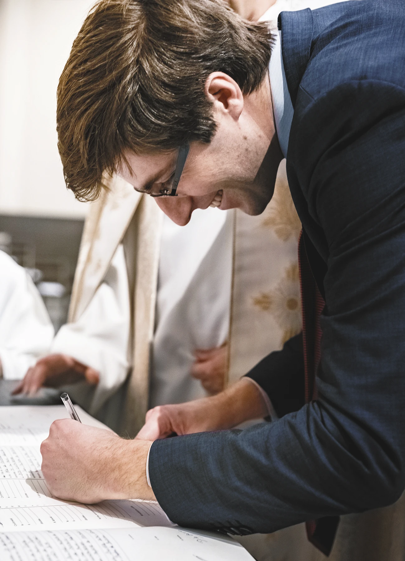Un homme signe le registre après la cérémonie de baptême.