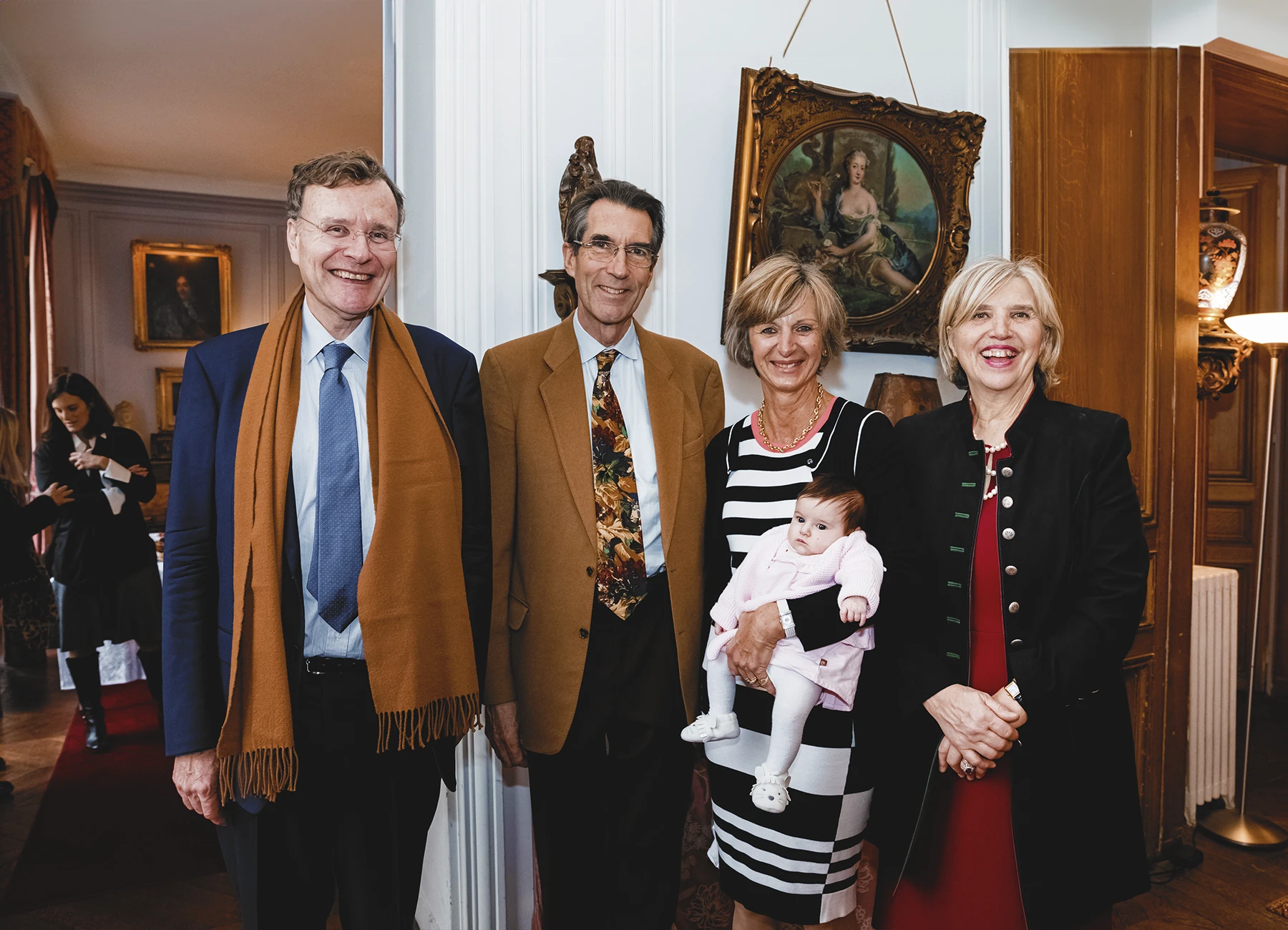 Groupe dans le salon, incluant le petit-fils du général De Gaulle et une femme tenant un bébé.