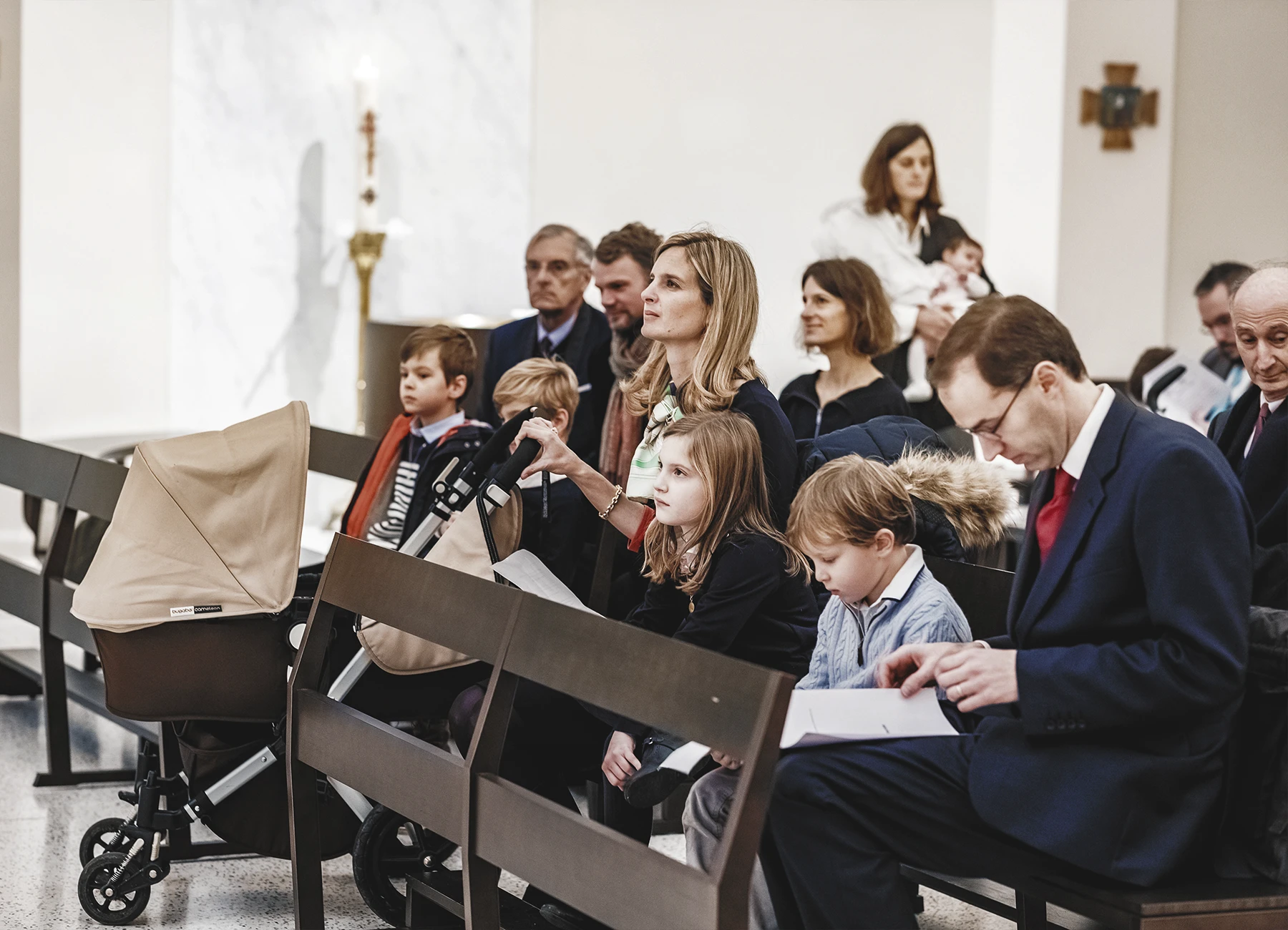 Invités assis dans l’église en attente du début de la cérémonie de baptême