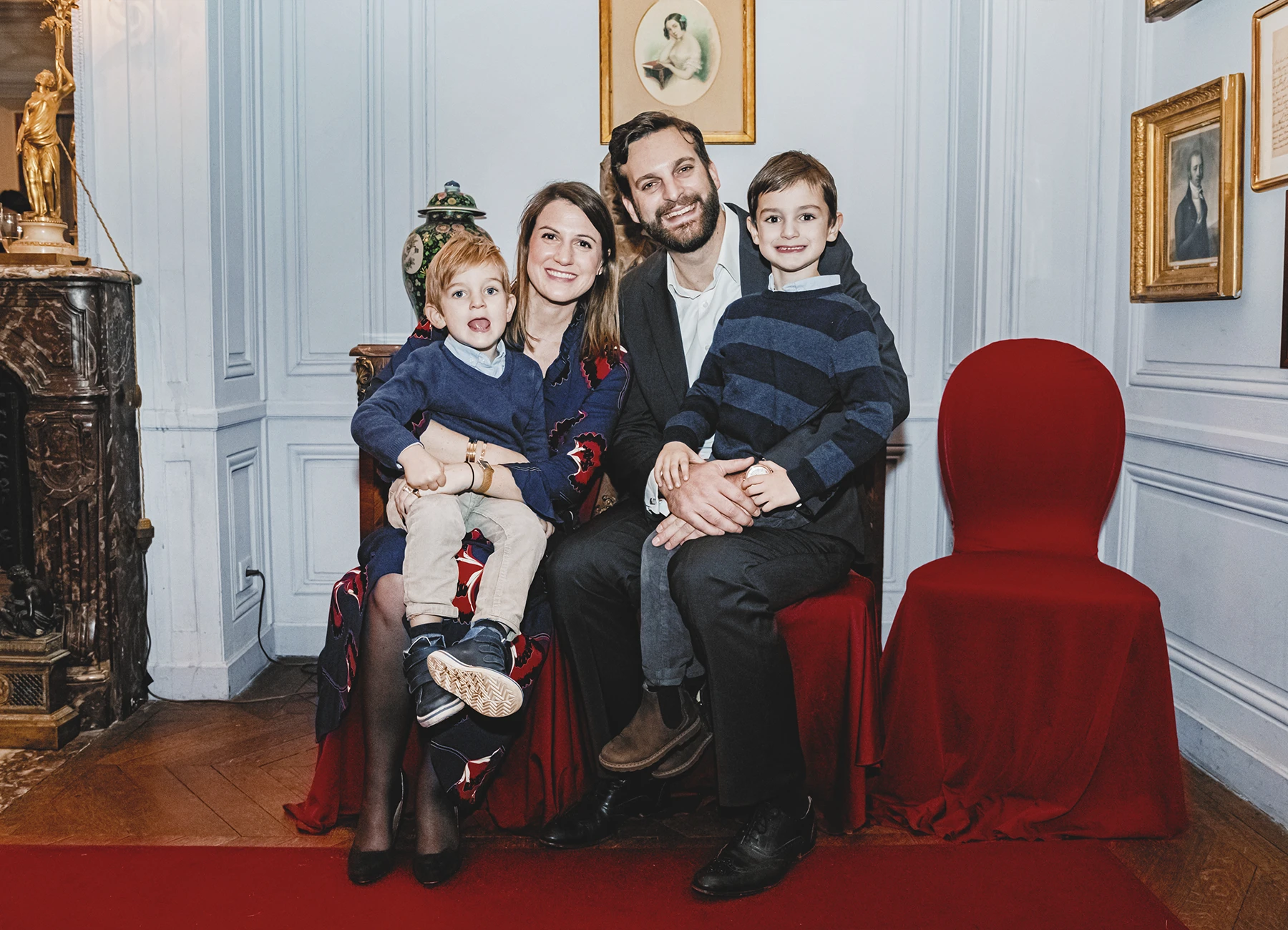 Portrait de famille montrant les parents et leurs deux fils, capturé dans une ambiance festive.