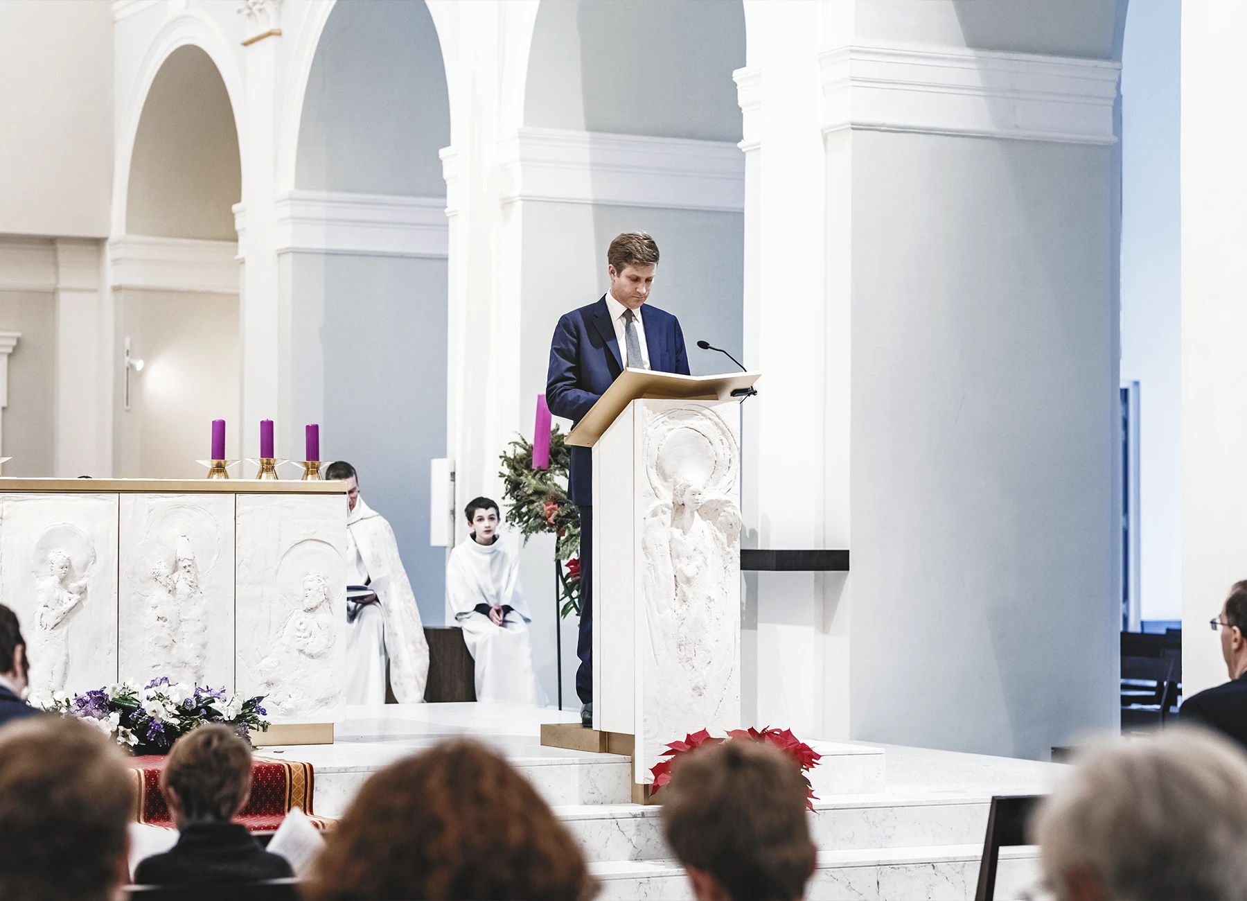 Un homme en costume prononçant un discours depuis l’estrade de l’église