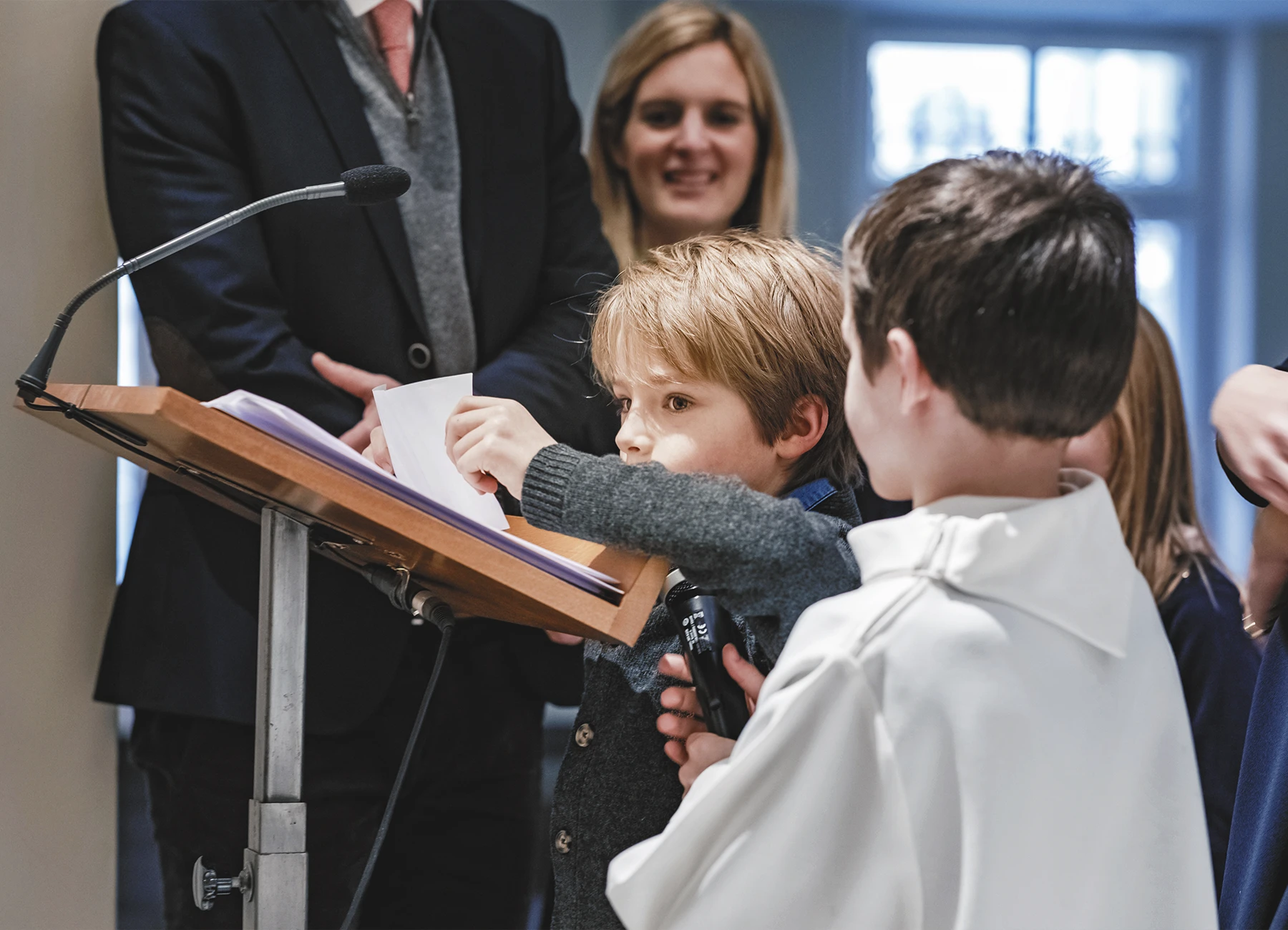Un petit garçon récitant une prière durant la cérémonie de baptême