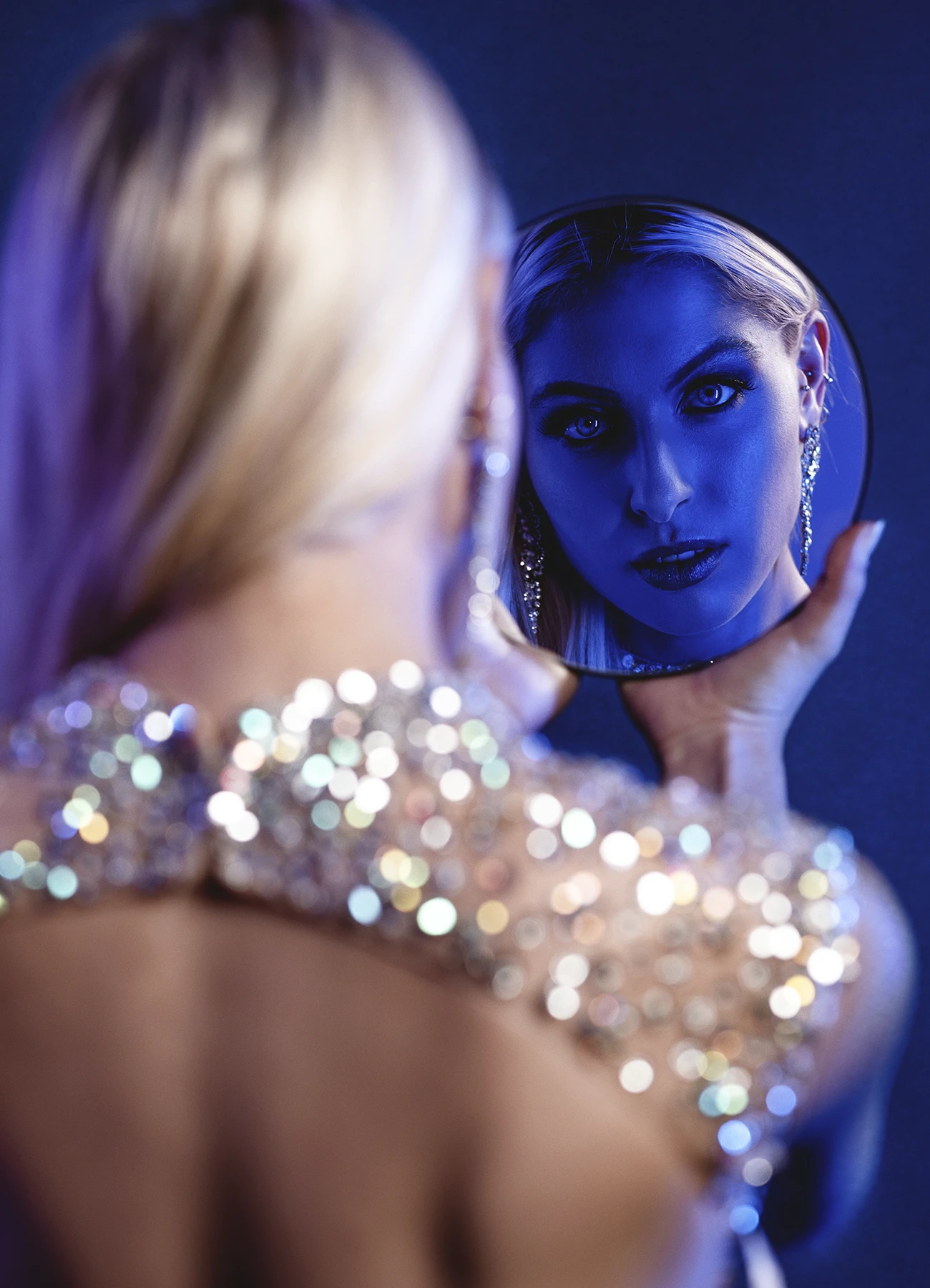 Focus sur le reflet de Candice dans un miroir qu'elle tient dans la main