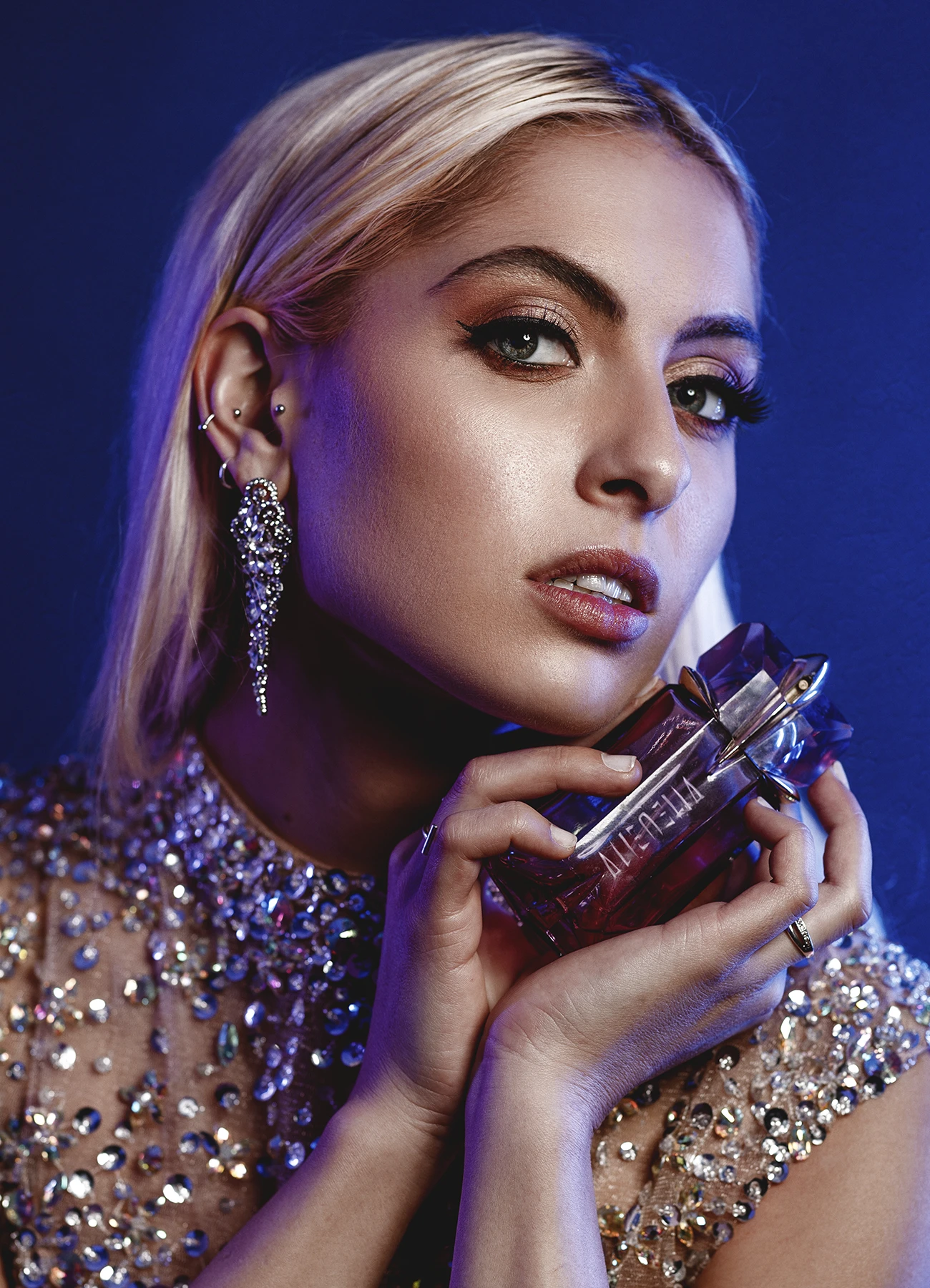 Candice en plan serré, tenant un flacon de parfum Alien de Thierry Mugler