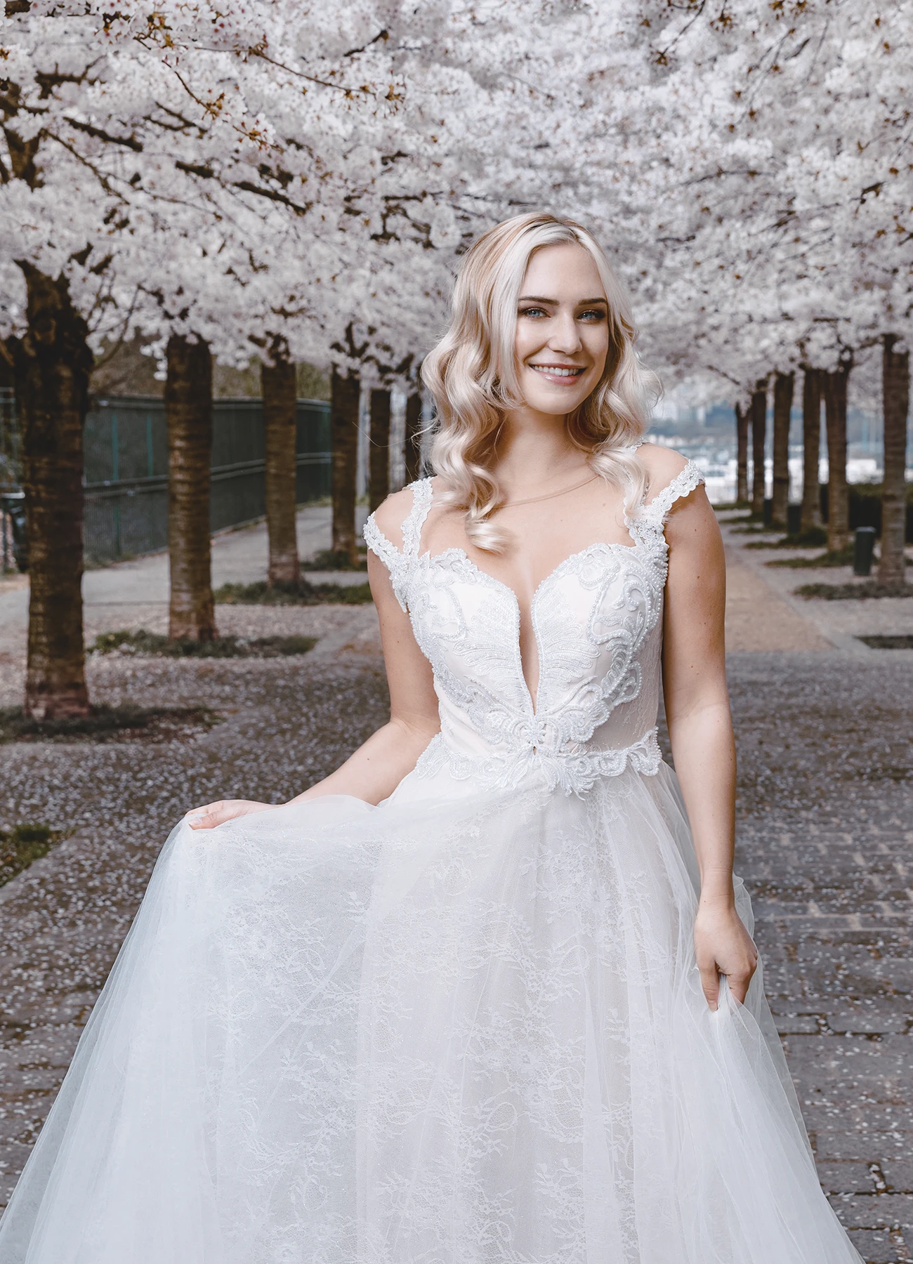 Eva Mikulski, en robe blanche, entourée de cerisiers en fleurs à Romainville