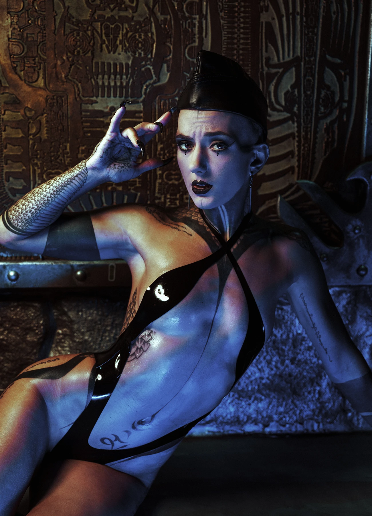 Gros plan sur Léa Montravers posant devant une peinture de Giger au bar BlackDog