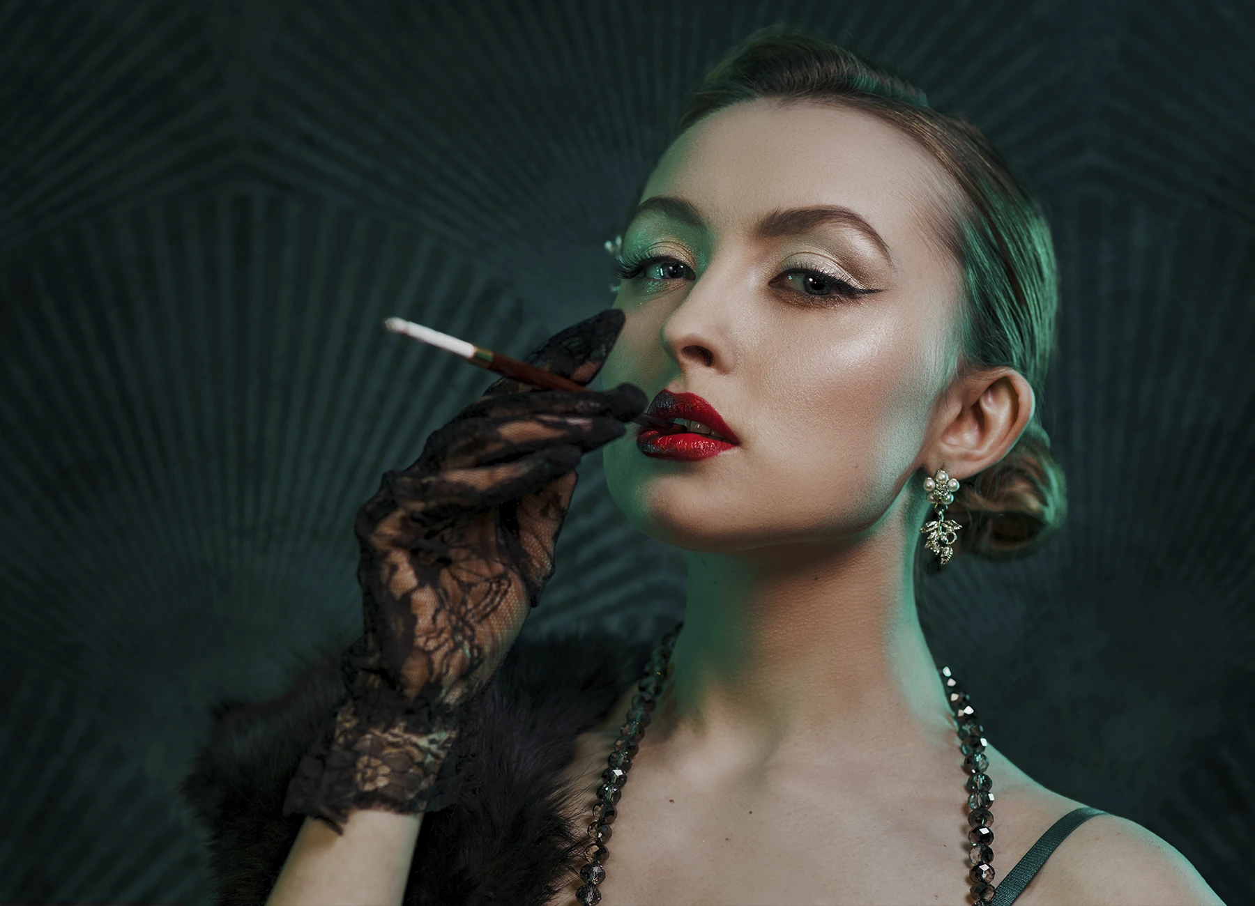 Kalysta en tenue style années 20, tenant un porte-cigarette avec une cigarette à sa bouche, photo en studio réalisée par Laurène Zabary.