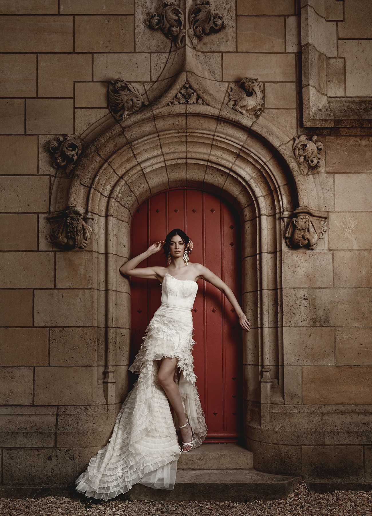 Susana en robe de mariée Elyssa Couture posant devant la porte rouge de la bibliothèque Forney, photographie de mode en extérieur par Laurène Zabary.