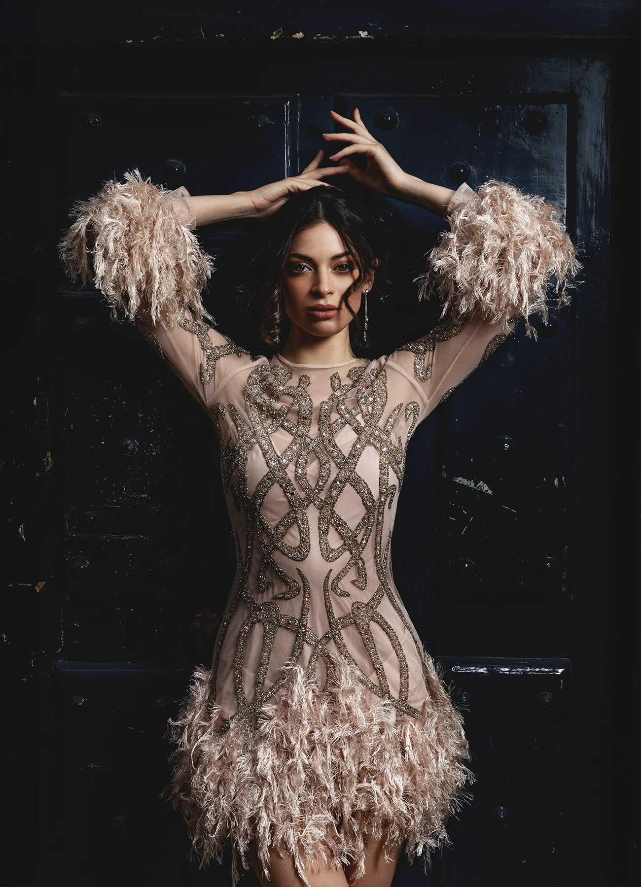 Modèle en robe Elyssa Couture appuyée contre une porte en bois bleue, photographie de mode en extérieur par Laurène Zabary.