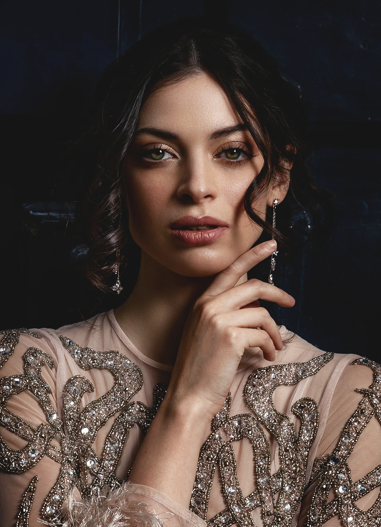 Portrait serré d'une modèle en robe Elyssa Couture devant une porte en bois bleue, photographie de mode en extérieur par Laurène Zabary.