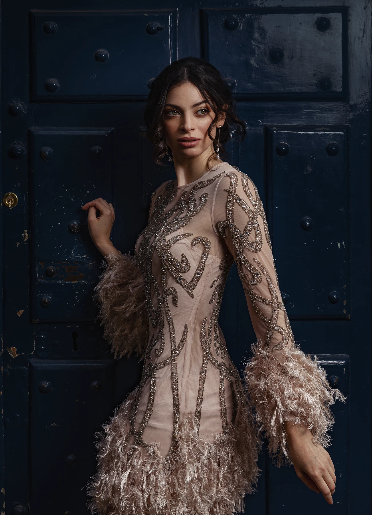 Modèle en robe Elyssa Couture posant devant une porte en bois bleue, photographie de mode en extérieur par Laurène Zabary.