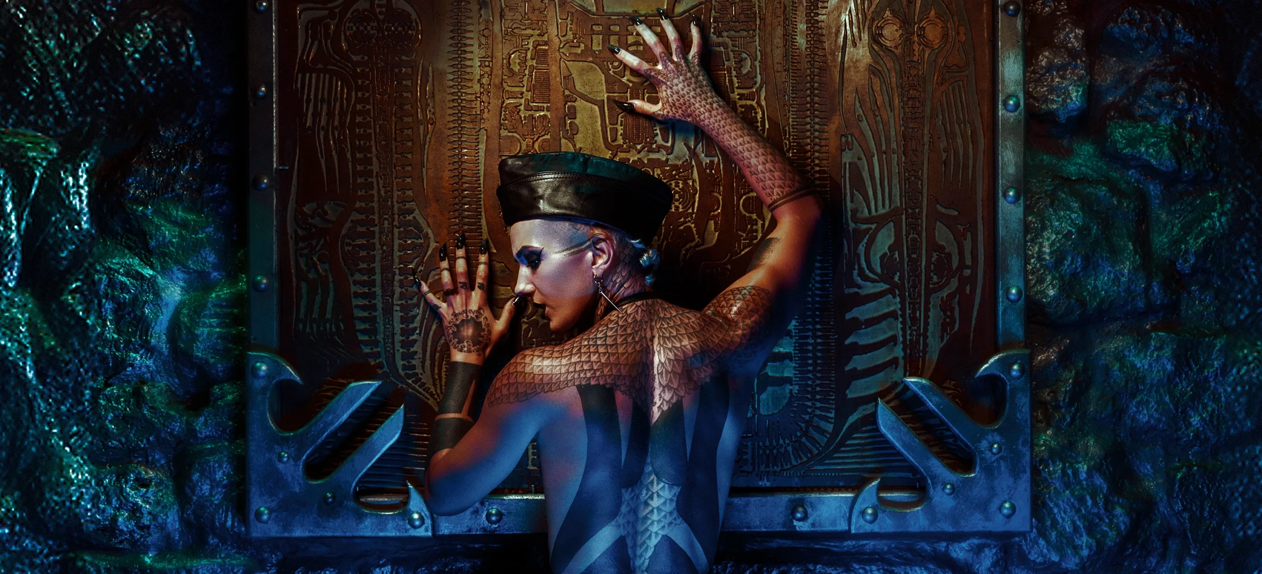 Léa Montravers de dos grattant l’œuvre de Giger sur le mur au bar BlackDog, vêtue d'un body noir minimaliste