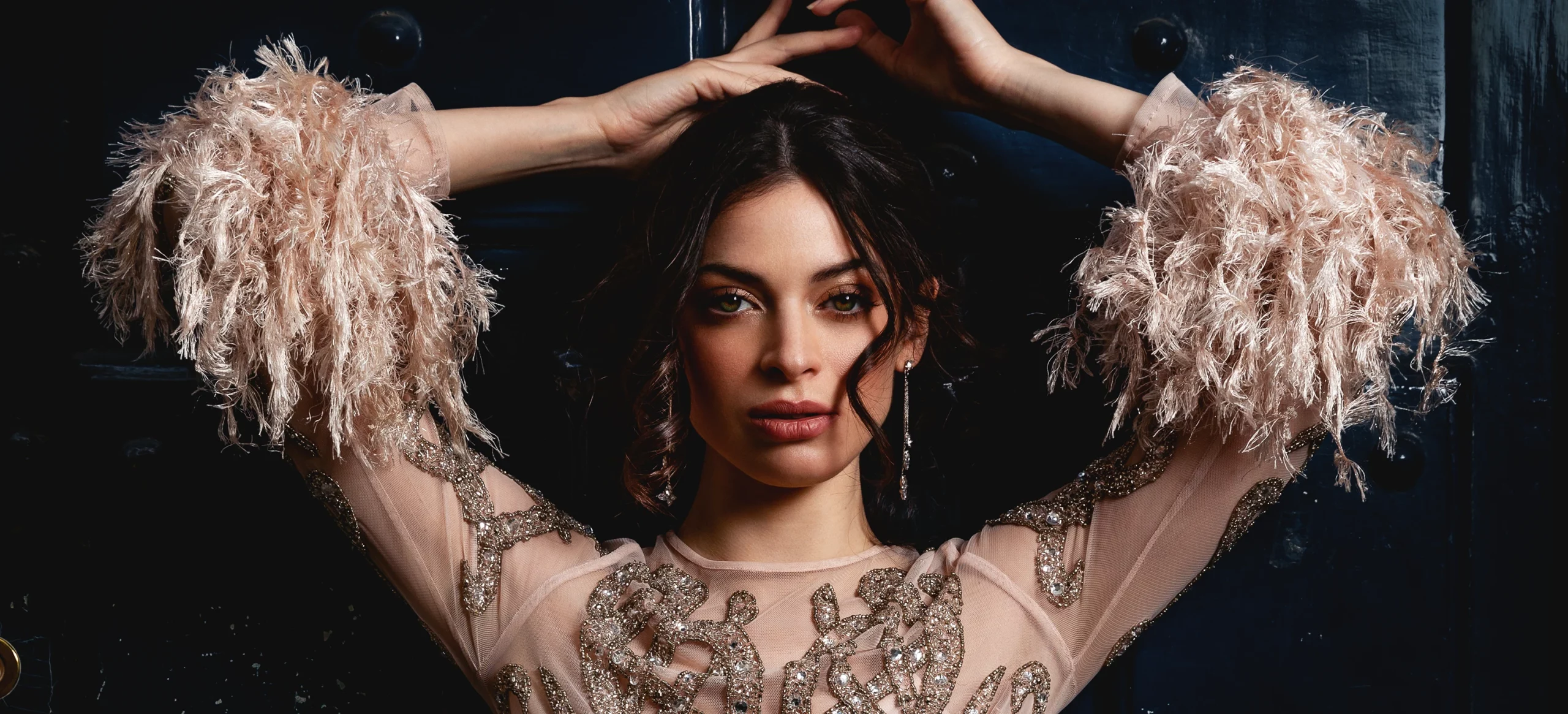 Modèle en robe de couturier appuyée contre une porte, photographie de mode prise en extérieur par Laurène Zabary.