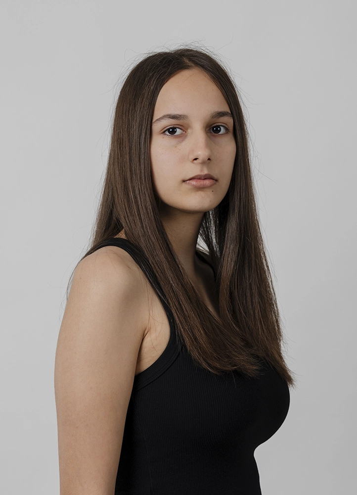 Polaroid mannequin d’Alyaa en pied de face, tenue noire sobre, réalisé en studio à Paris.