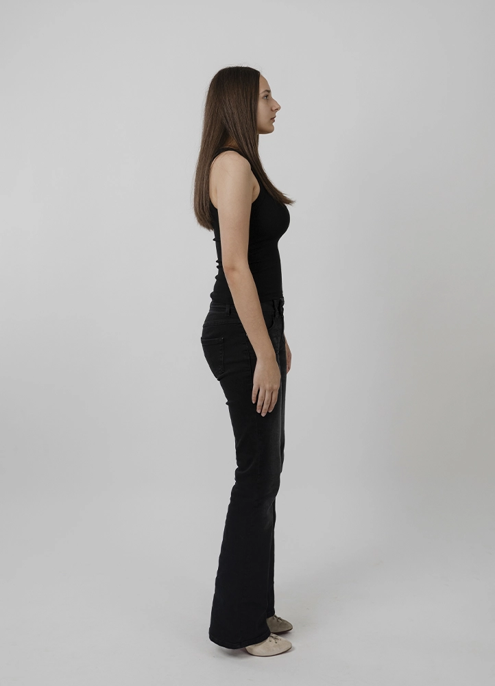 Polaroid mannequin d’Alyaa en pied de face, tenue noire sobre, réalisé en studio à Paris.