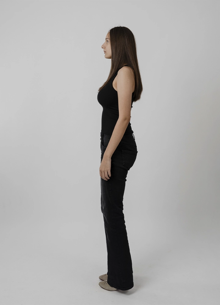 Polaroid mannequin d’Alyaa en pied de face, tenue noire sobre, réalisé en studio à Paris.