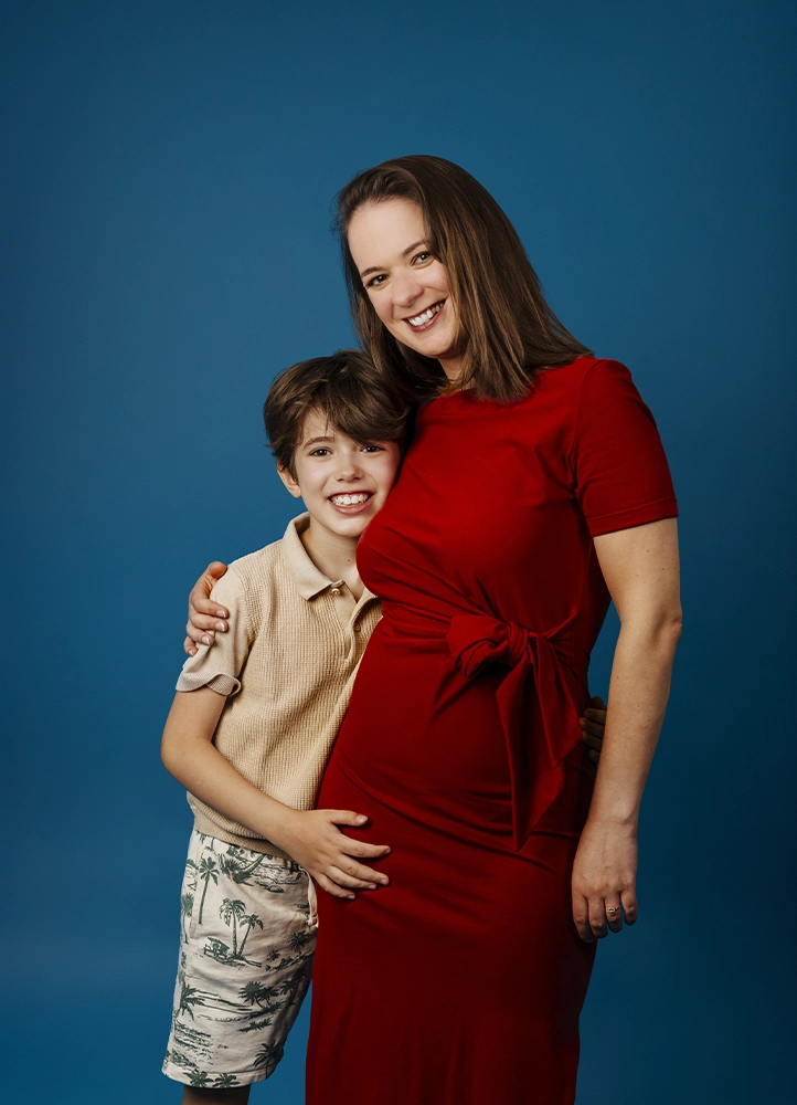 Laetitia Linossier et son fils posent ensemble devant un fond bleu lors d’une séance photo en studio.