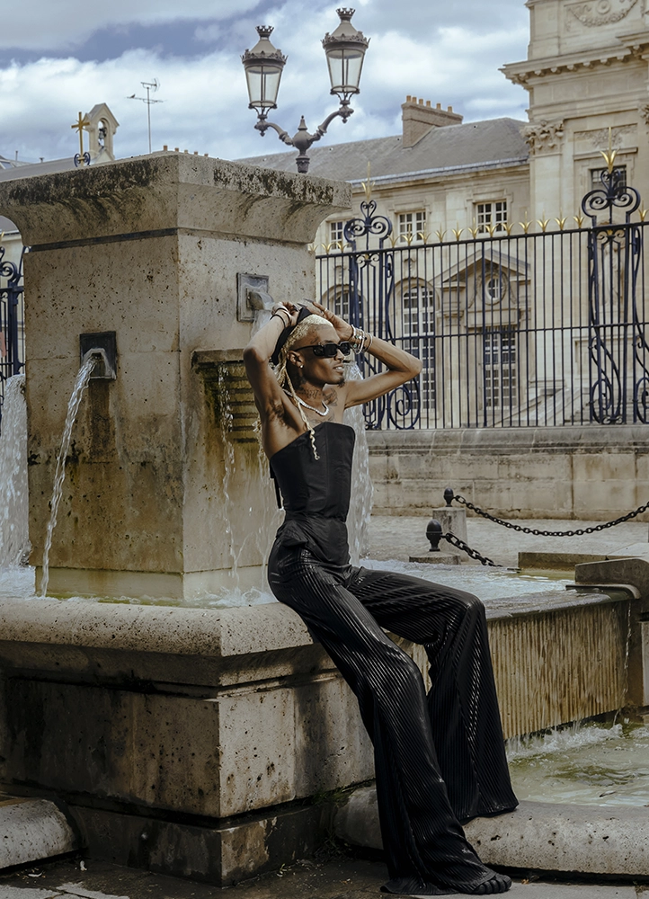 Be Norman assis près de la fontaine du Val-de-Grâce pendant un shooting mode à Paris.